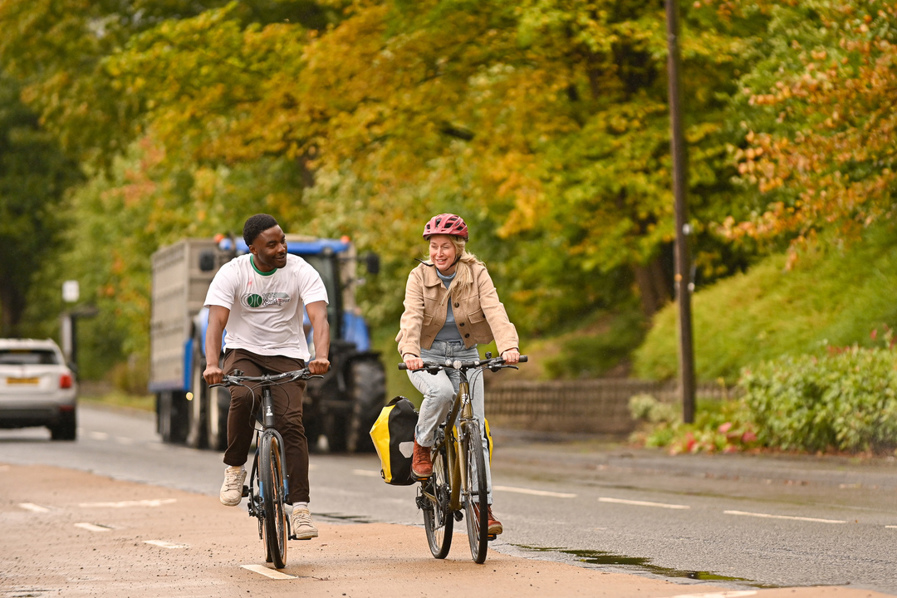 A man and woman riding bikes along a separated cycle lane in Stirling