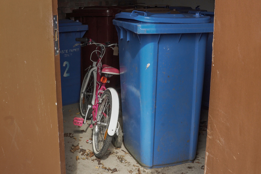 A bike is stored in a bin shed