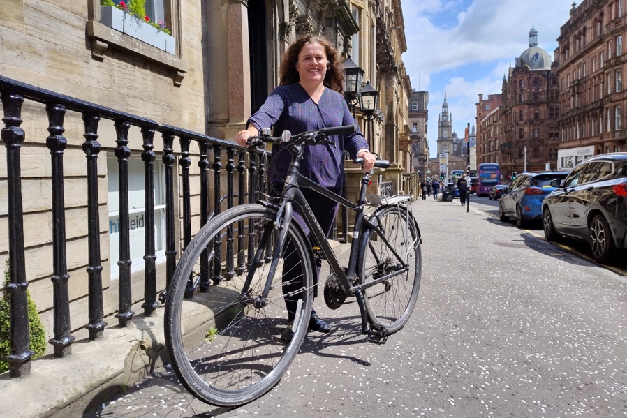 Clare pictured with her bike on a street in Glasgow city centre