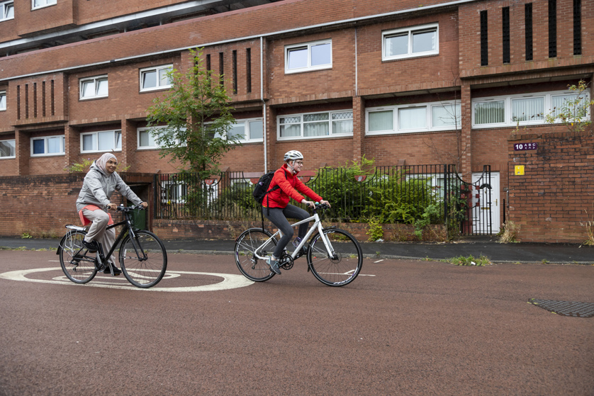 Two women cycling on an urban road