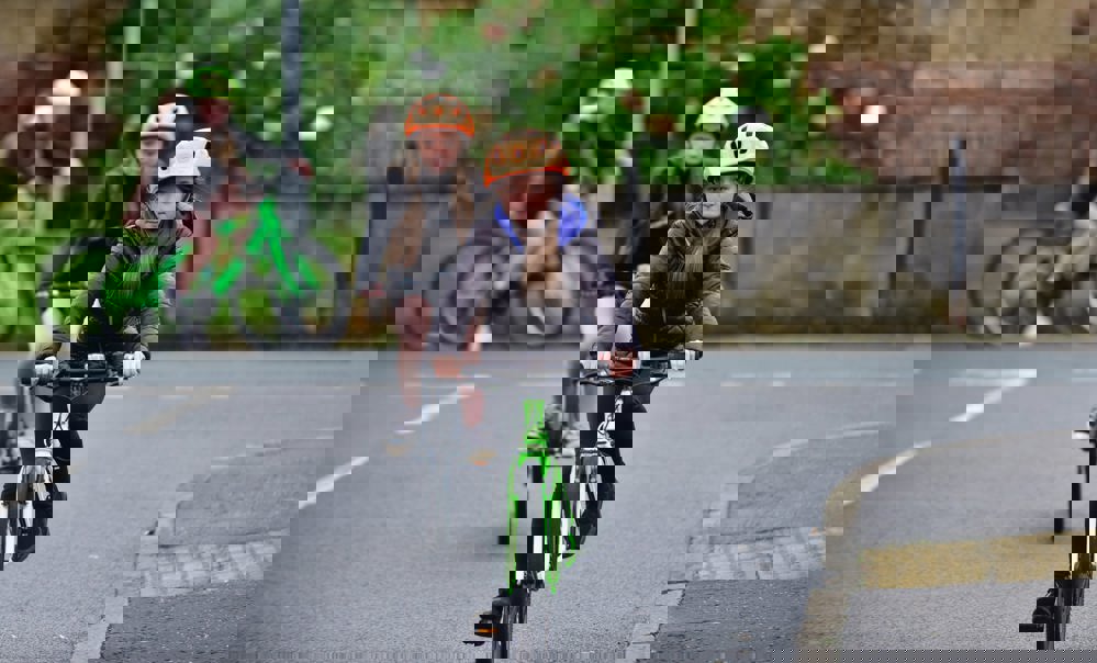 Two girls take part in Bikeability Scotland on-road cycle training on a residential street