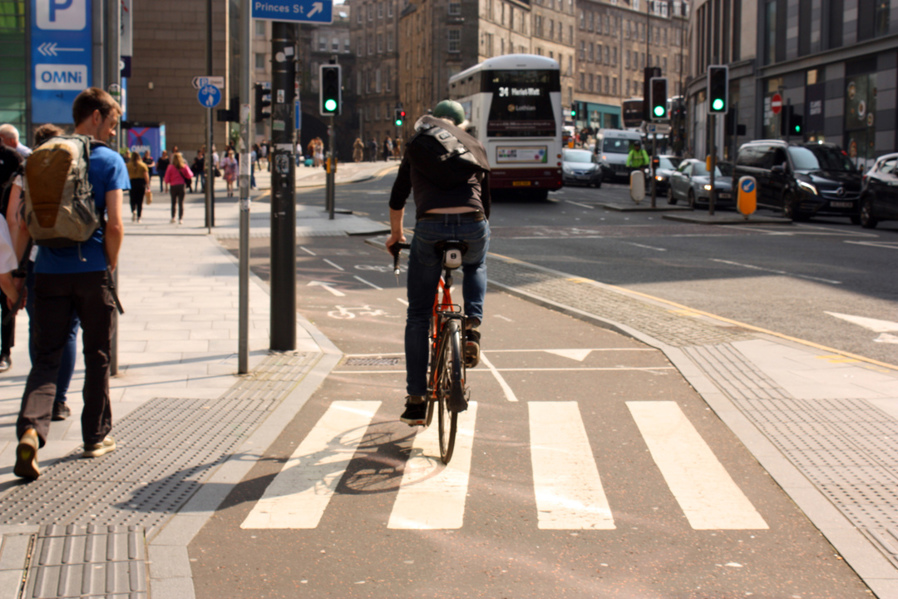 A person cycles on a bidirectional cycle lane at the top of Leith Walk in the centre of Edinburgh