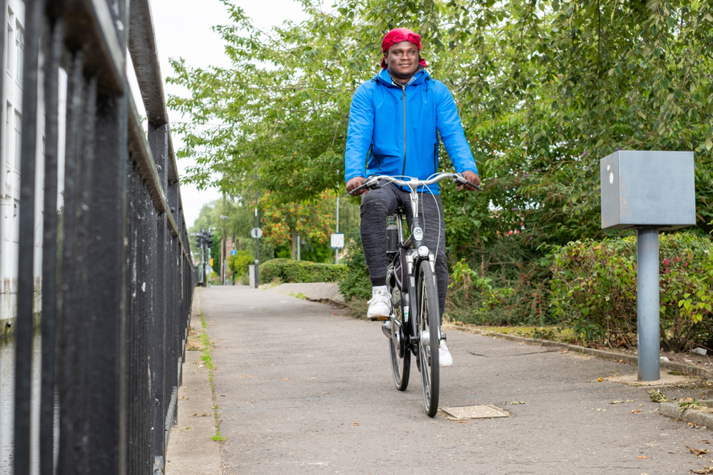 A man cycles past an automatic cycle counter on an off-road path