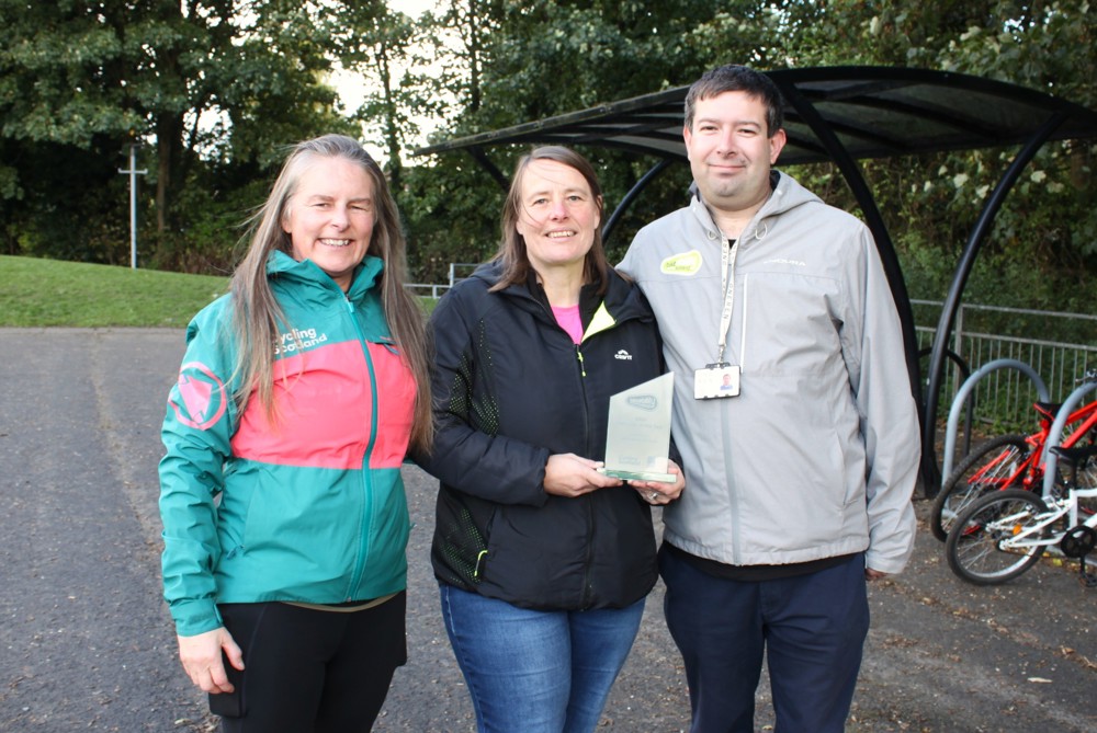 Jacqueline Doherty (centre) pictured holding her Bikeability Scotland Instructor of the Year 2026 award trophy, alongside Gillian Bond (left) and Craig Dalziel (right)